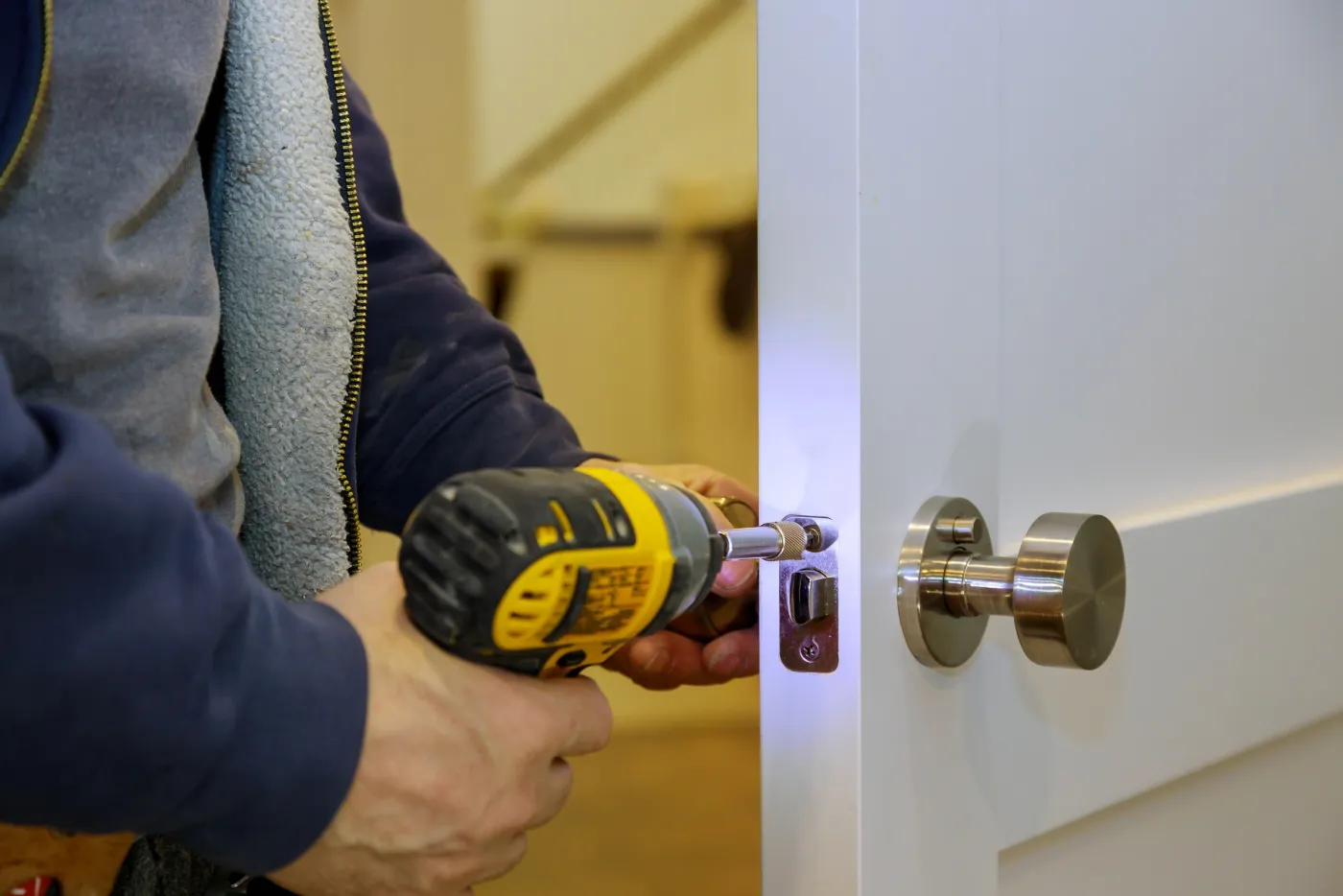 Pose d'un cylindre de sûreté sur une porte par un serrurier pour un site professionnel en Île-de-France